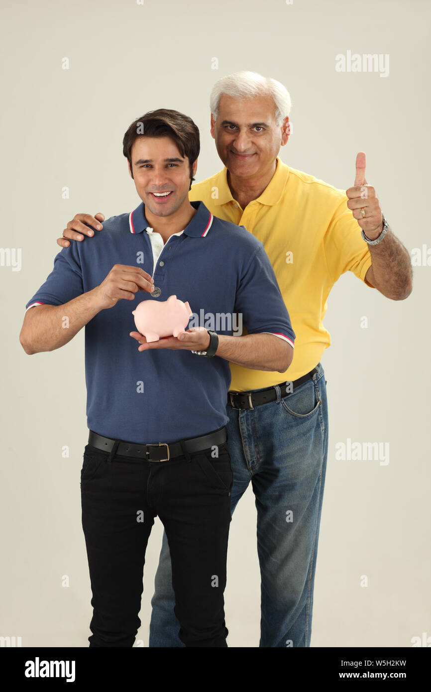 Father and son putting coin piggy bank hi-res stock photography and ...