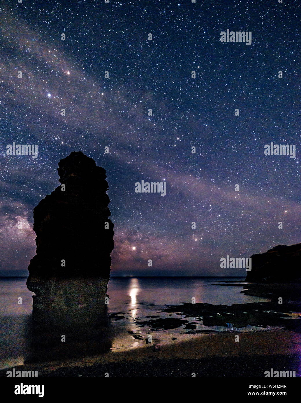 Milky Way and Jupiter beyond a majestic sea stack at Ladram Bay, Sidmouth, Devon, England, United Kingdom, Europe Stock Photo