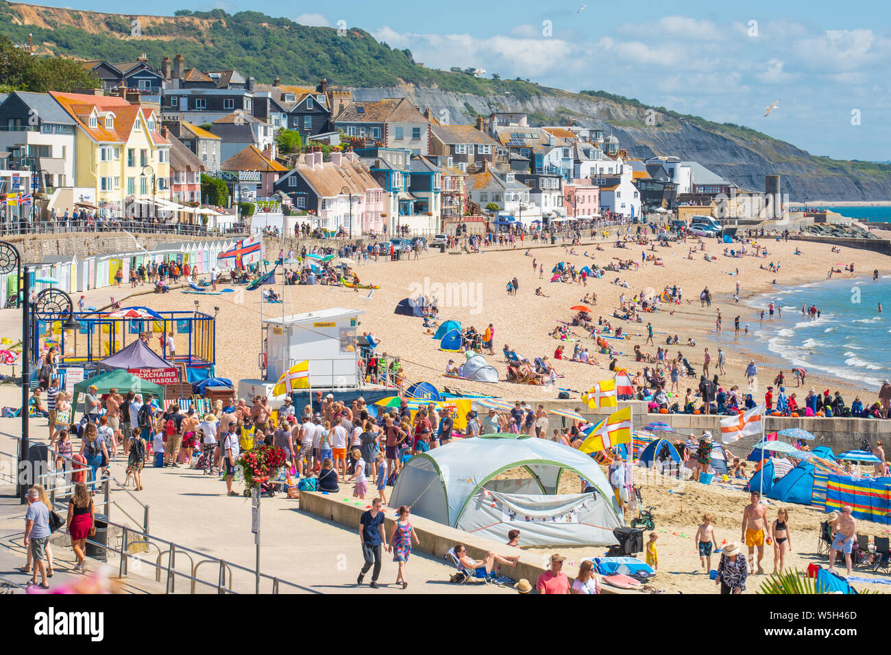 Lyme Regis, Dorset, UK. 29th July 2019. UK Weather: Another scorching hot start to the week at the picturesque seaside resort of Lyme Regis. Crowds of holidaymakers  and families pack out the beach to make the best of the baking hot sunshine over RNLI and Regatta week.  Credit: Celia McMahon/Alamy Live News. Stock Photo