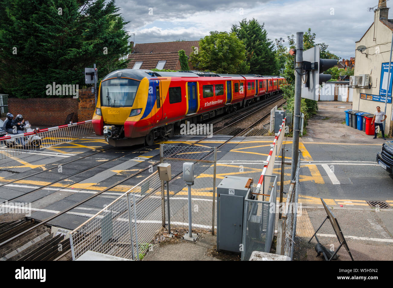 A South Western Railway train passes through a level crossing  at Datchet in Berkshire, UK Stock Photo
