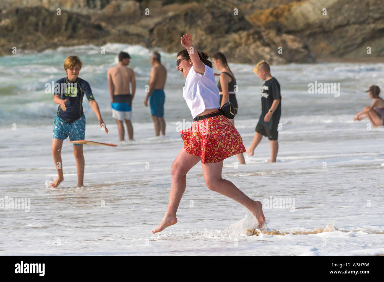 A female holidaymaker enjoying being at the seaside on Fistral Beach in Newquay in Cornwall. Stock Photo