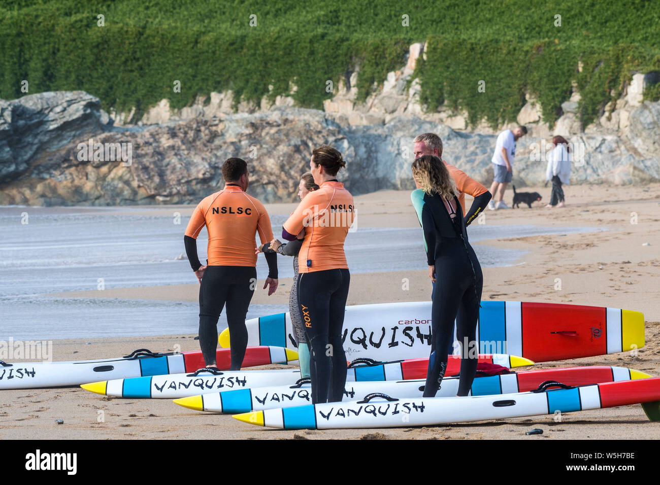 Members of Newquay Surf Life Saving Club with their Vanquish Life Saving Race Board waiting to start a training session at Fistral in Newquay in Cornw Stock Photo