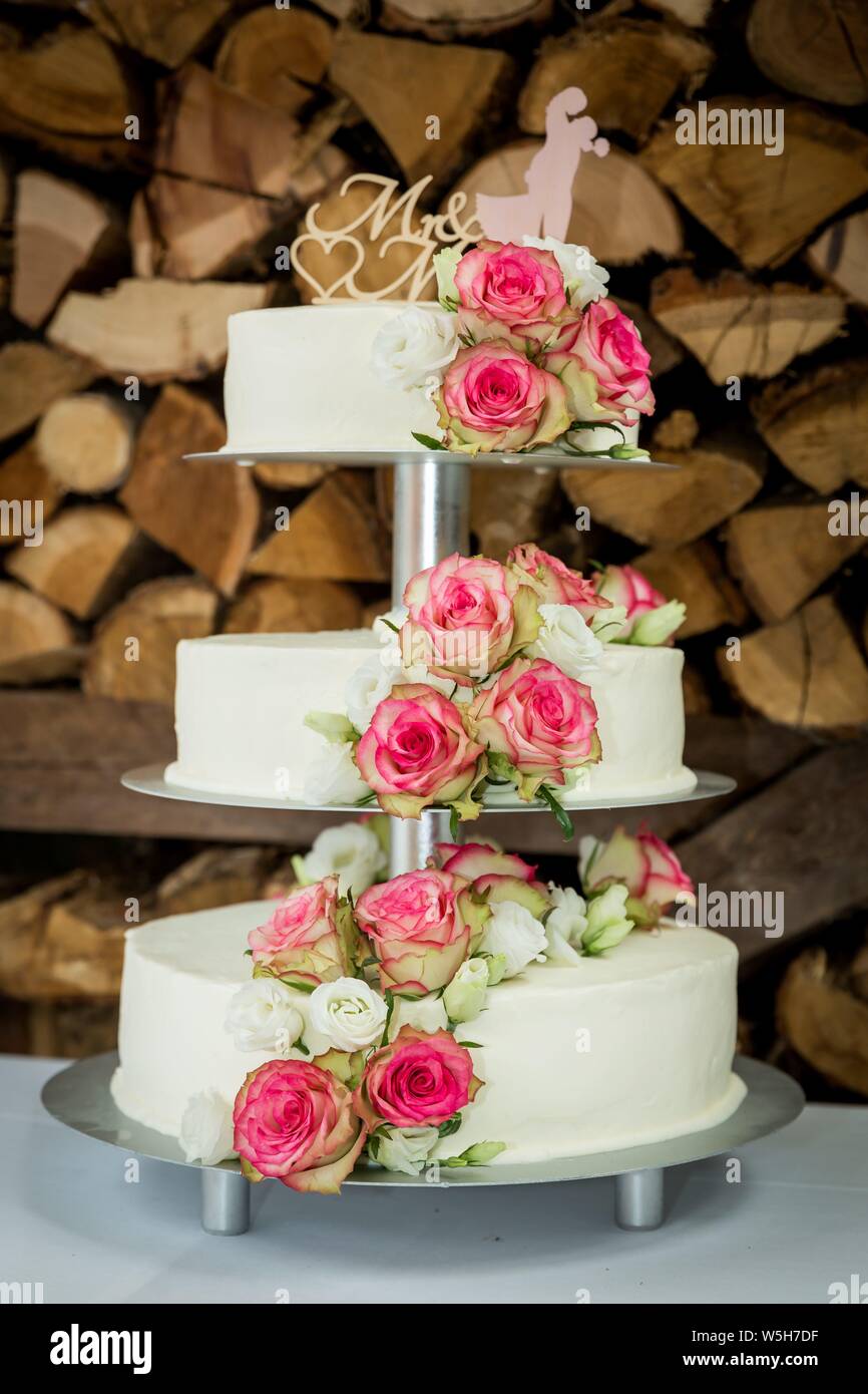 Symbolic photo on the subject of wedding and marriages. A three-tiered wedding cake with floral decoration of roses and the lettering 'Mr. & Mrs.'. | usage worldwide Stock Photo