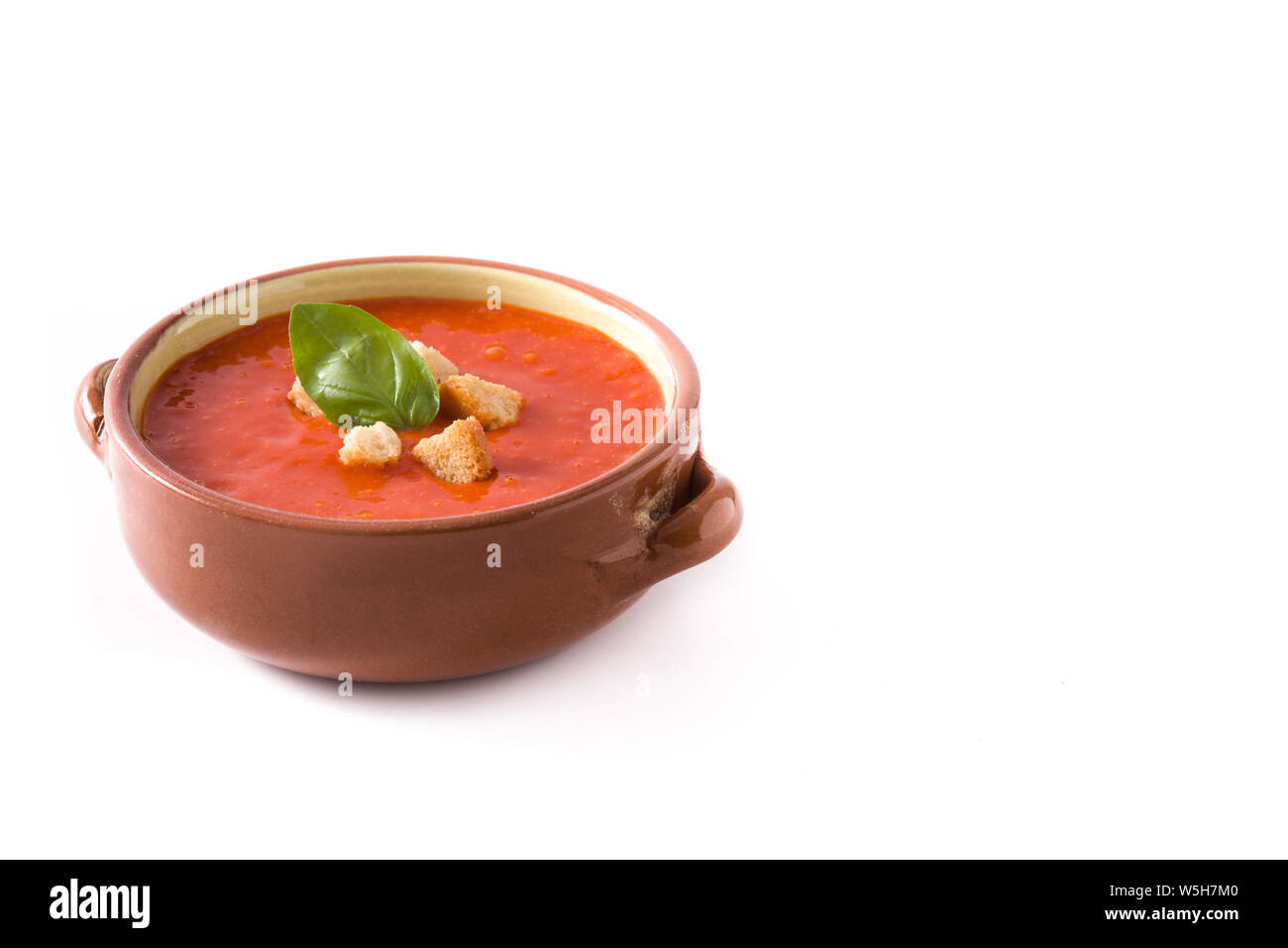 Tomato soup in brown bowl isolated on white background. Copyspace Stock Photo