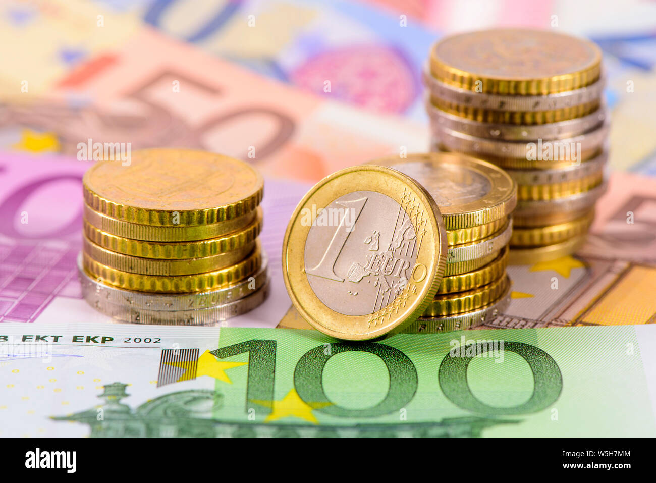 heap of many Euro currency banknotes with stacked coins Stock Photo