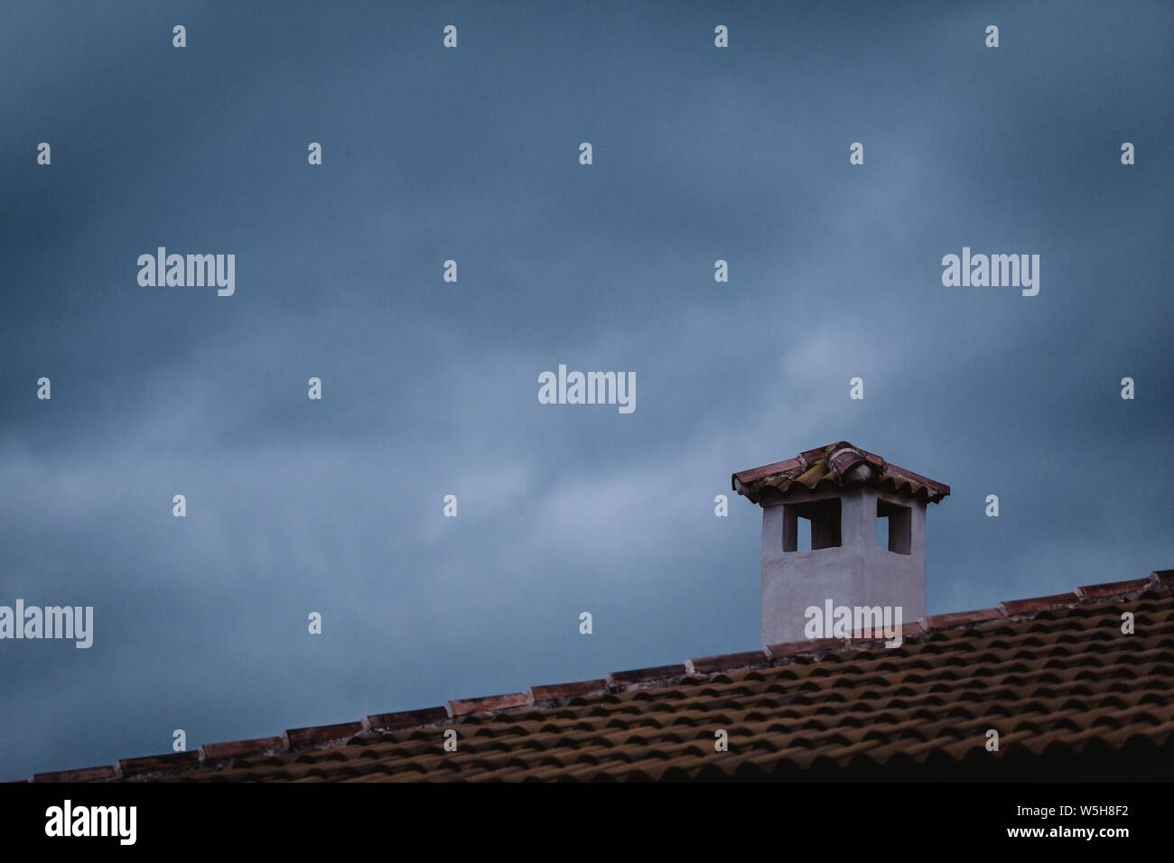 Beautiful shot of a white and brown chimney on brown roof Stock Photo