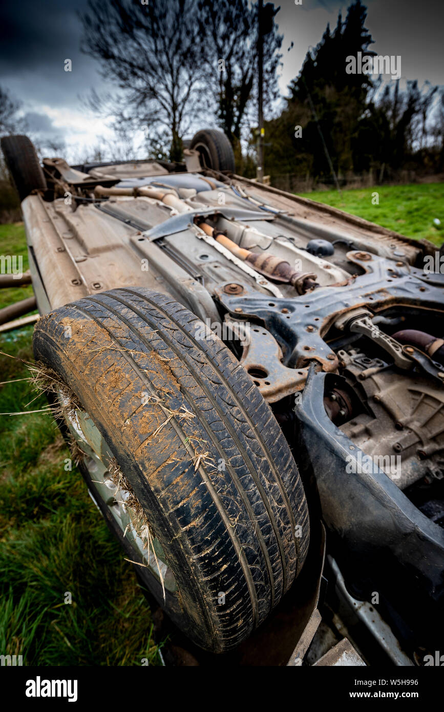 Car crash. Young drivers overturned vehicle. Non fatal accident caused by speeding and rain. Inexperienced driver / Rural crime / Stolen car / rtc. UK Stock Photo