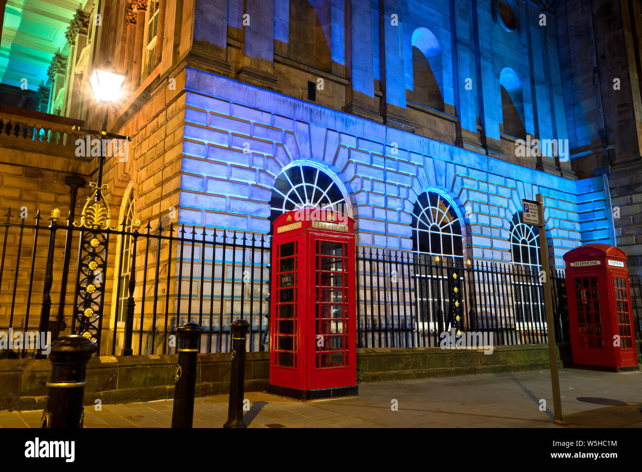Classic Red British telephone boxes at the side of an illuminated