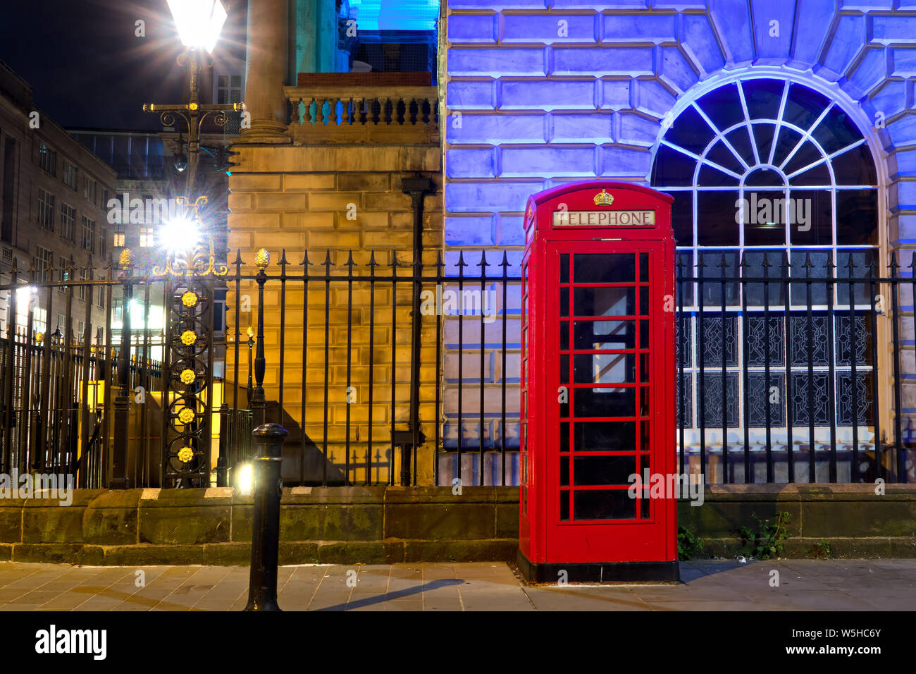 Classic Red British telephone boxes at the side of an illuminated