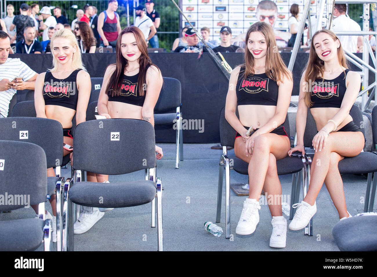 Ring card girls rest at ringside during a break between undercard fights at Kiev Parkovy Convention Artem Dalakian WBA Fly Weight world title defense. Stock Photo