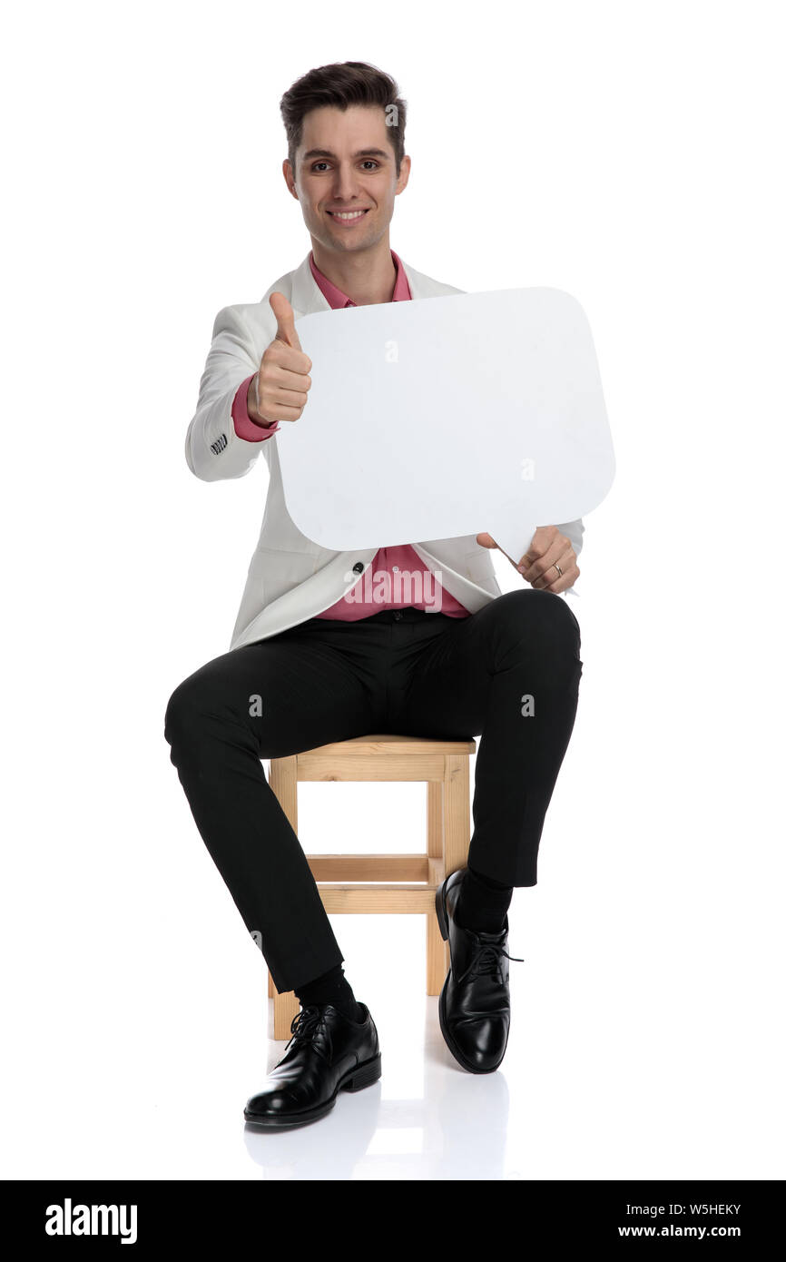 young smart casual man makes the ok sign while holding a speech bubble ...