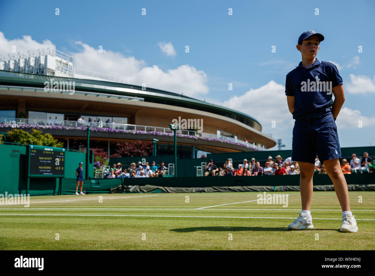 A ball boy during a tennis match with Number 1 Court behind at The Championships , Wimbledon