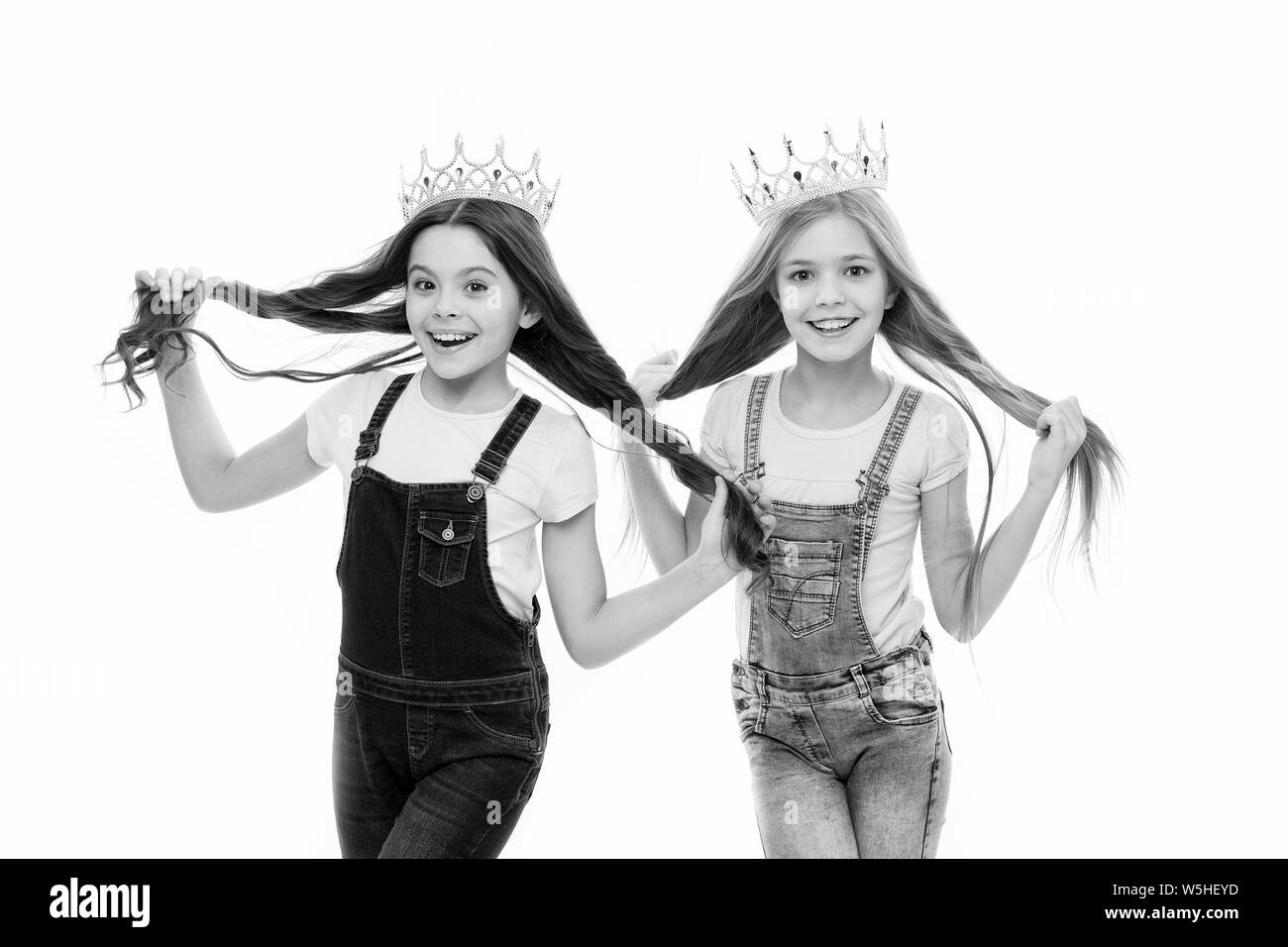 Spoiled children concept. Egocentric princess. Kids wear golden crowns symbol princess. Every girl dreaming become princess. Little princess. Self confidence. Leadership concept. Girls wear crowns. Stock Photo