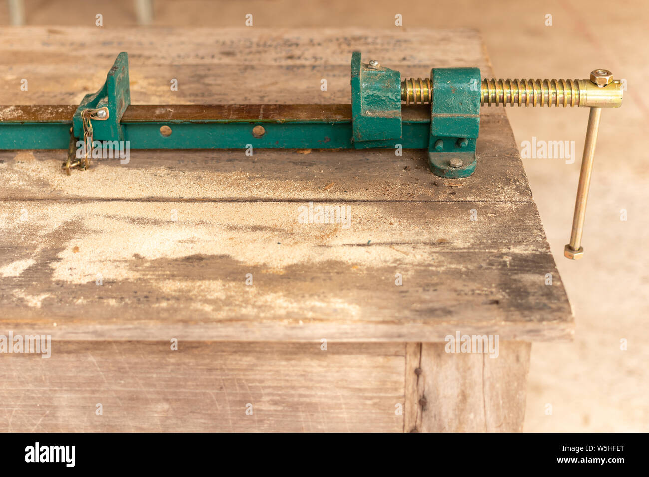 Workpiece clamp, Metal table vise clamp on the wood table. Copy space for text. Stock Photo