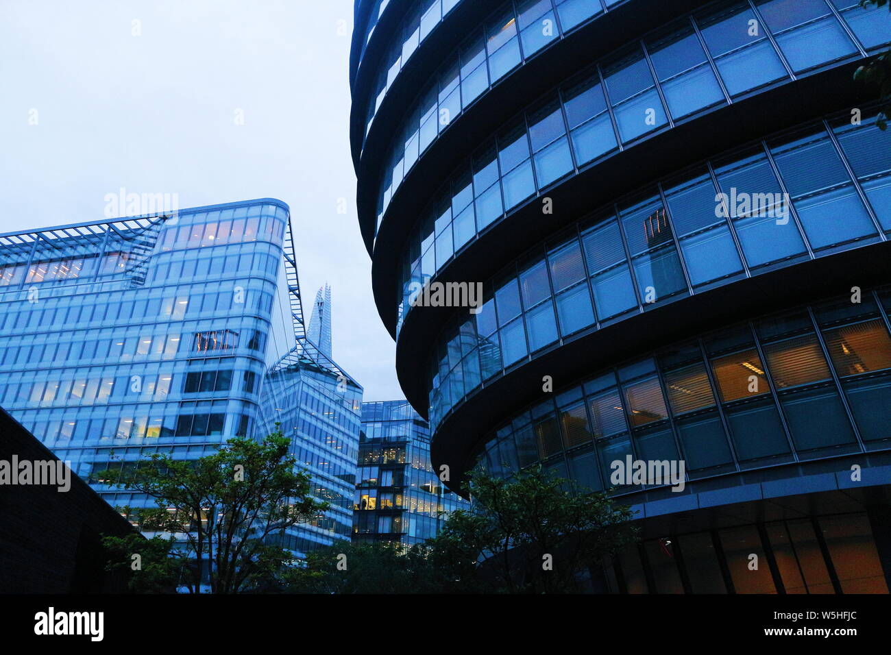 A building in London, UK in a bluish colour and lots of windows shot in an low-angle perspective. The photo was taken at night and on a cloudy day. Stock Photo