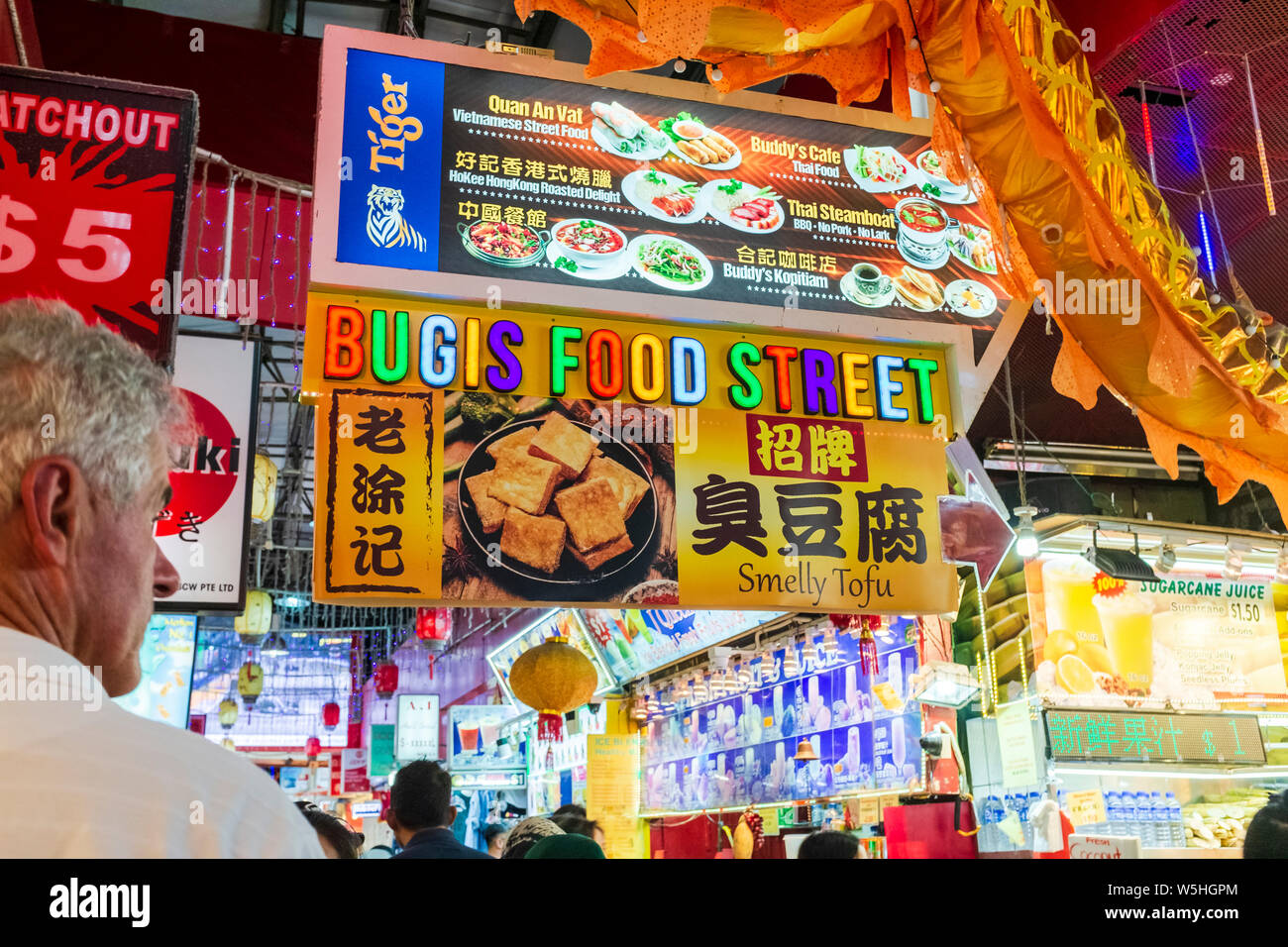 Caucasian male tourist with Bugis food street market sign at popular Bugis market in Singapore Stock Photo
