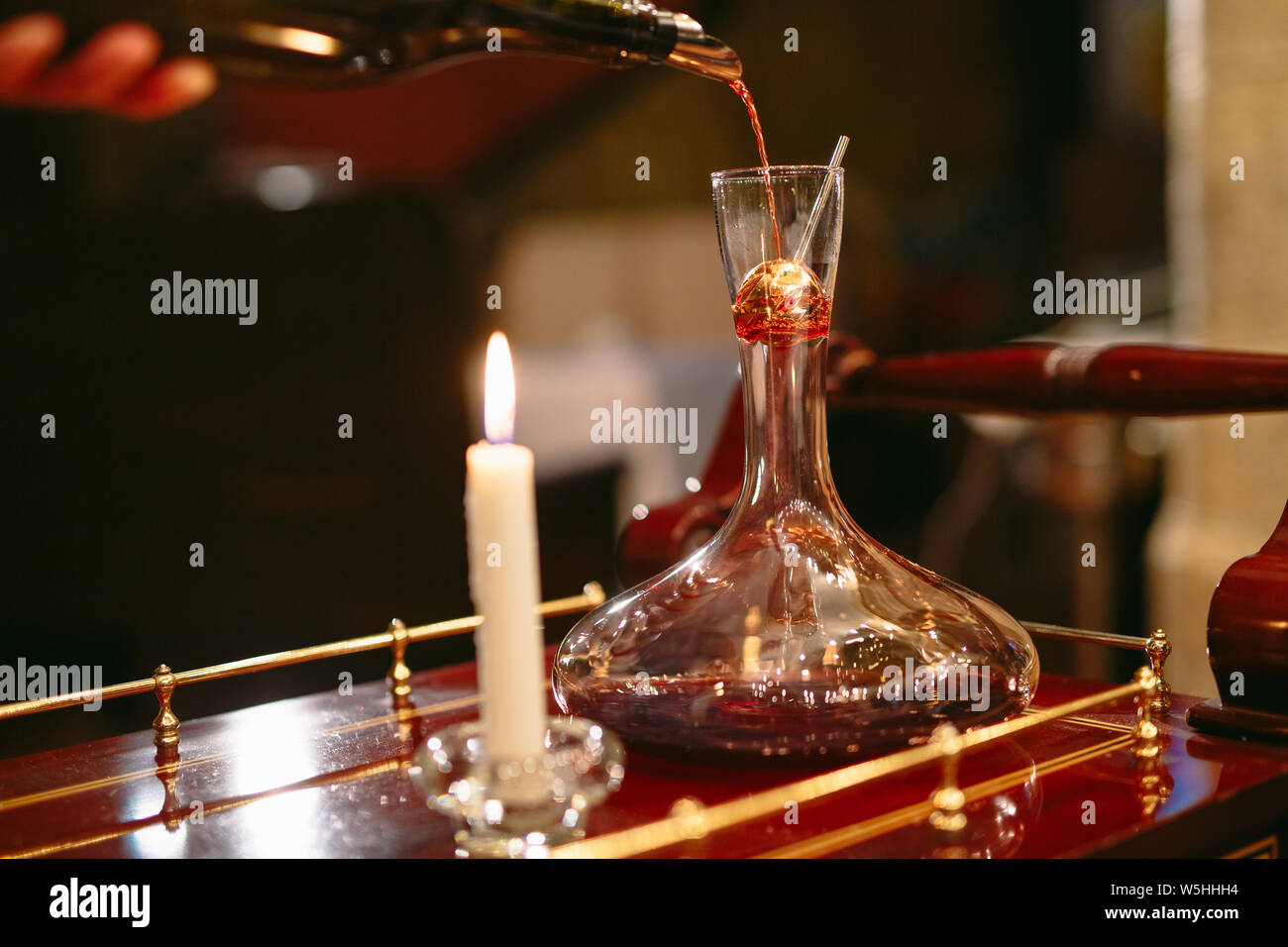 A sommelier pouring red wine into decanter Stock Photo Alamy