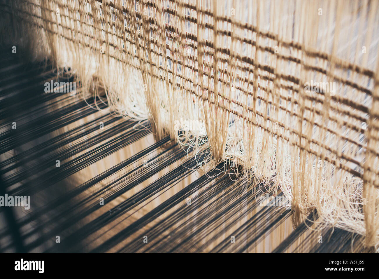 Weaving cotton and silk threads inside the loom Stock Photo