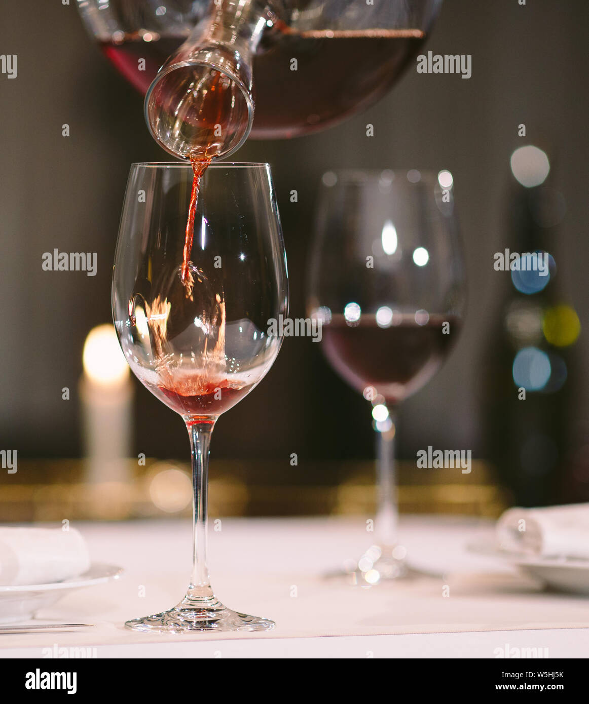 A sommelier pouring red wine into decanter Stock Photo Alamy