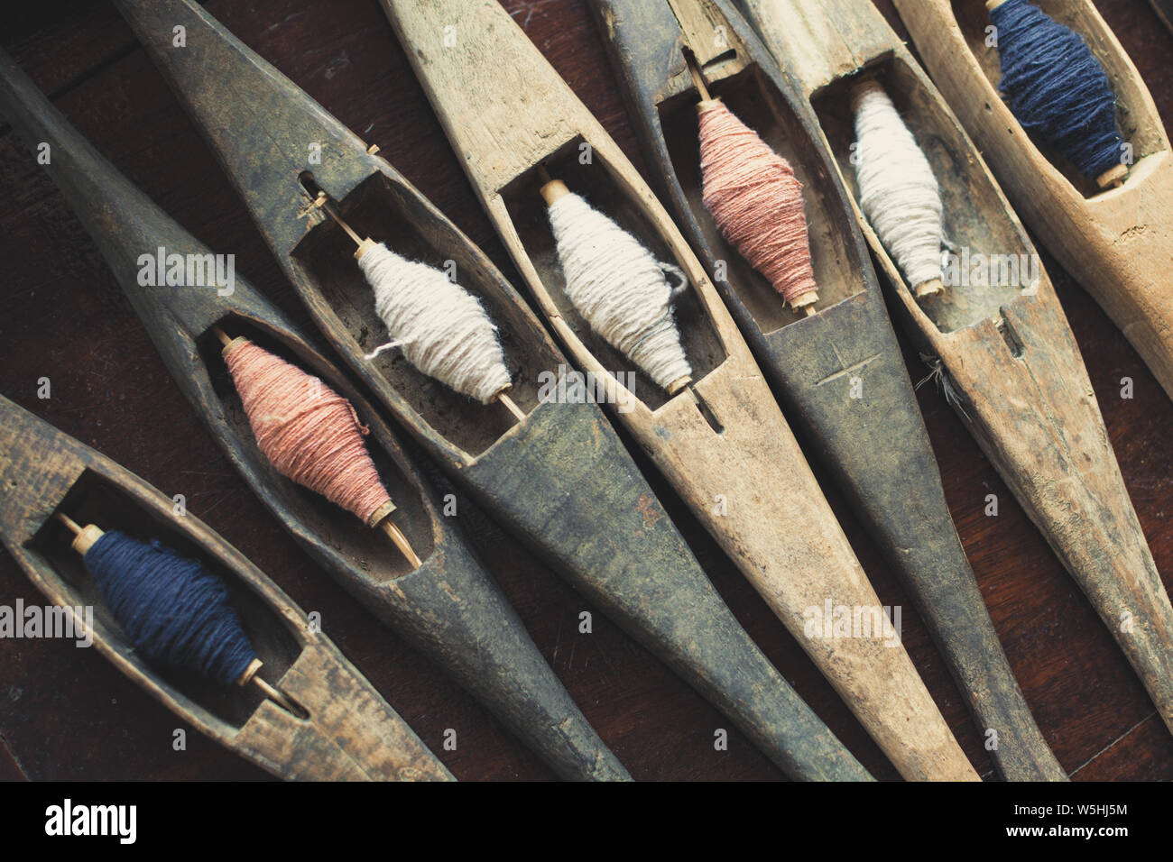 Vintage filling carriers of the loom with spool of colorful threads inside Stock Photo
