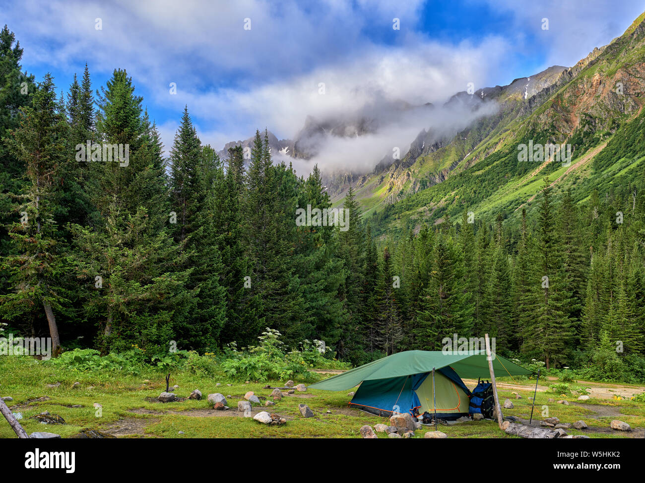 Hiking. One tent is set near mountain forest. Outdoor activities. Eastern Siberia Stock Photo