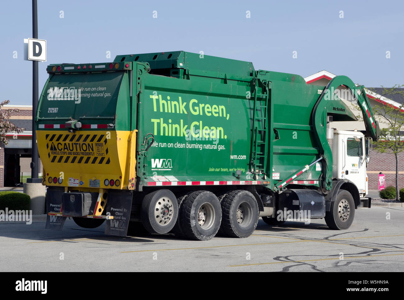 Waste Management natural gas powered trash collection or garbage truck bearing Think Green, Think Clean motto. Stock Photo
