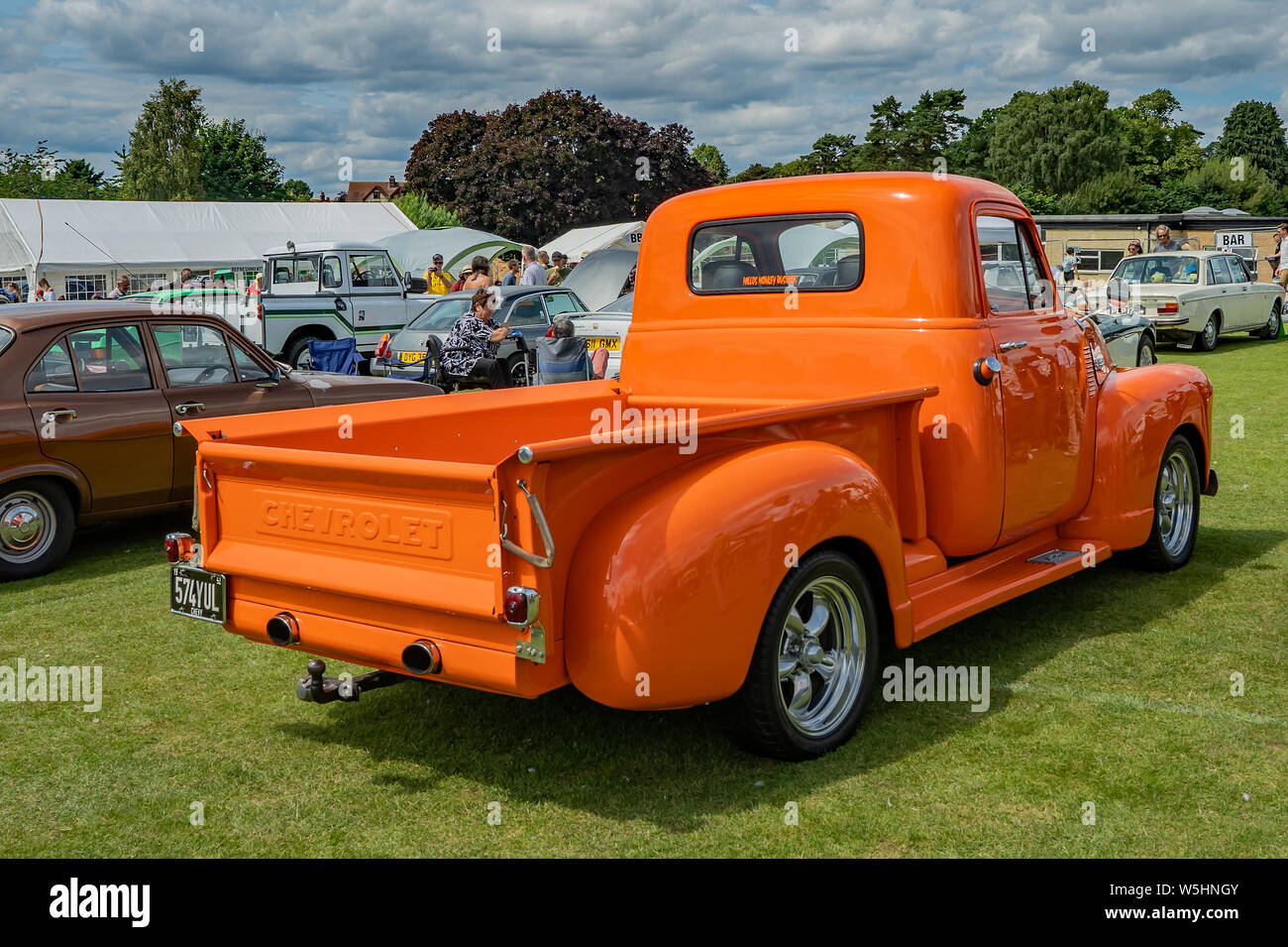 Rear view of a classic Chevrolet pickup truck, in bright orange, on display at the annual classic and vintage car show held in Wroxham, Norfolk, UK Stock Photo