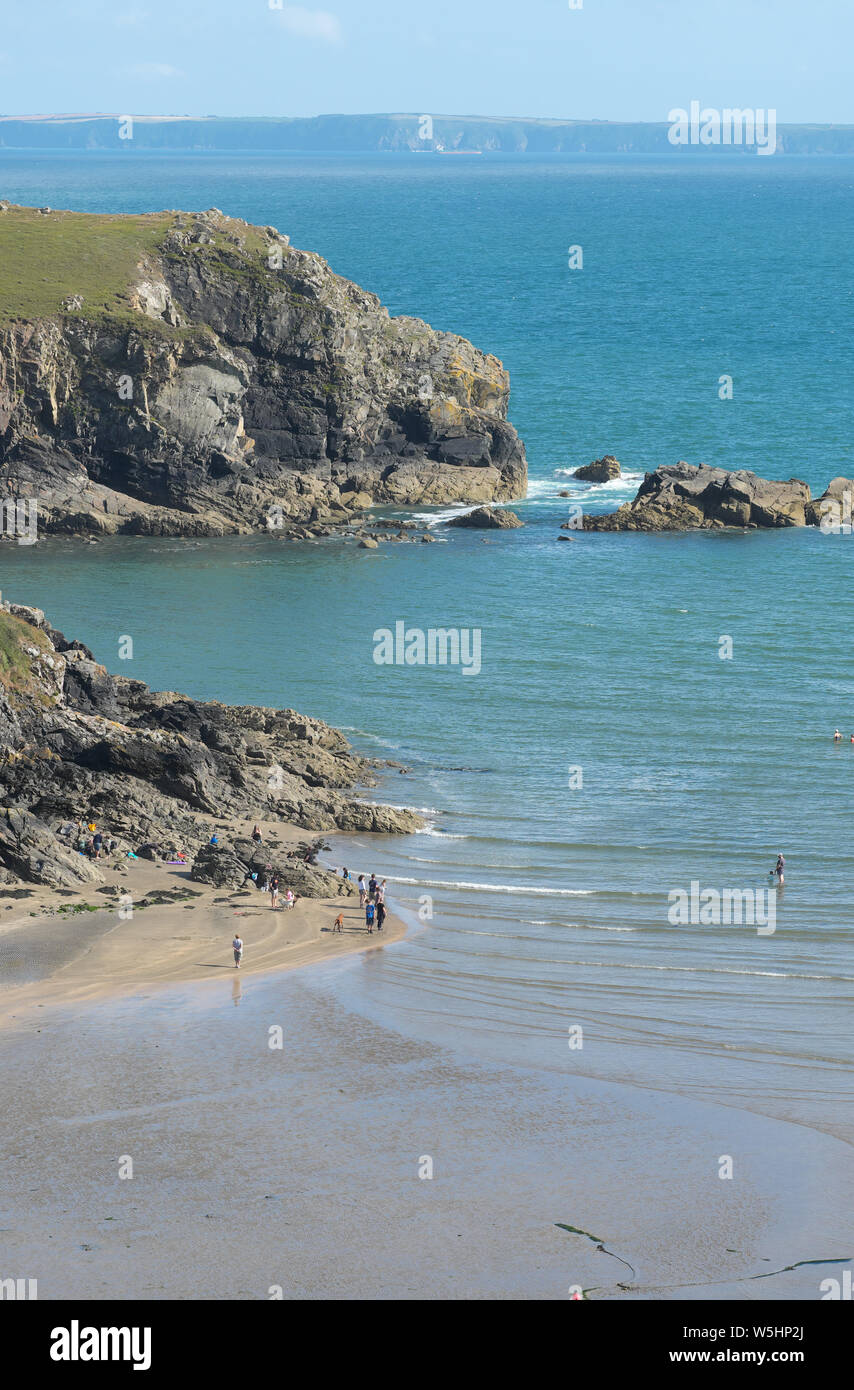 Solva, Pembrokeshire, Wales, UK visitors paddle on the beach at low tide in summer July 2019 Stock Photo