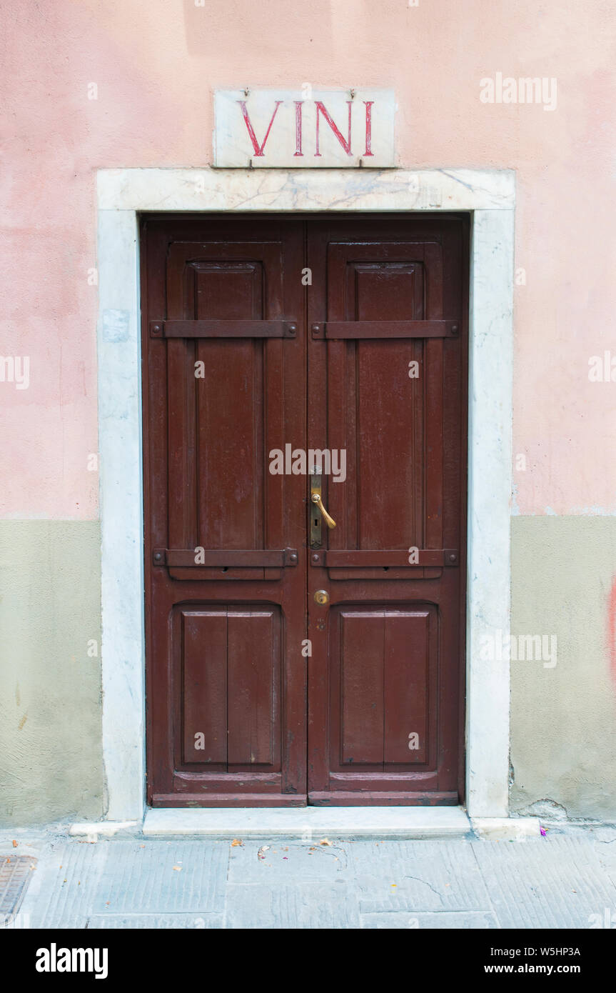 View of Carrara, Tuscany: ancient wood door of a wine shop with marble sign and the word wine Stock Photo