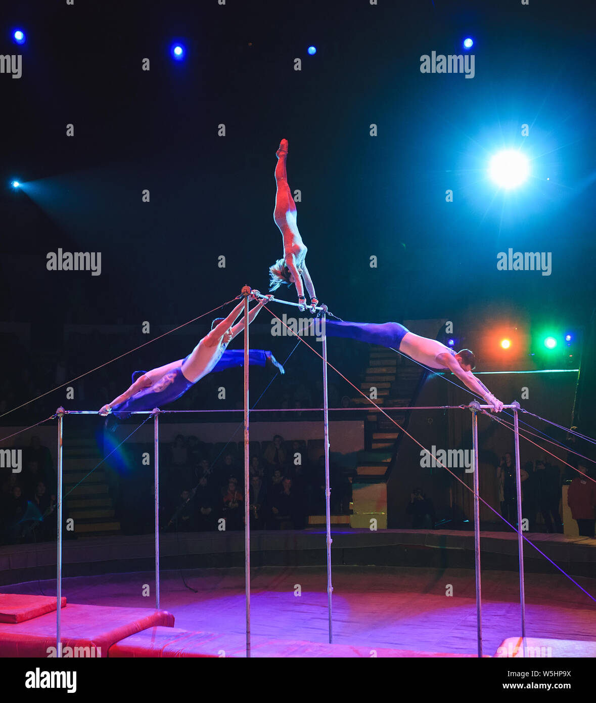 Acrobats perform exercises on the bar in the Circus arena Stock Photo