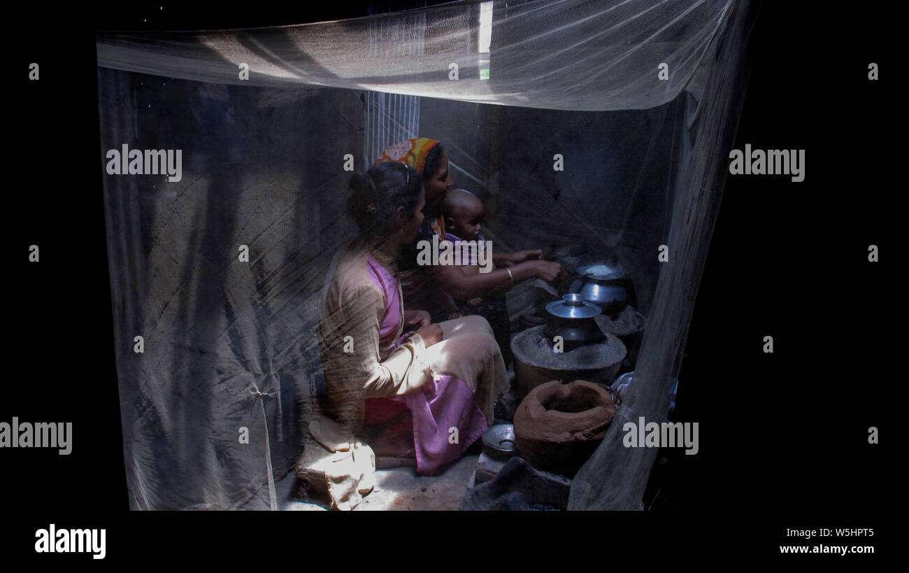 A mother pulls a mosquito and cooks to save her daughter from dengue mosquitoes© Nazmul Islam / Alamy Stock Photo Stock Photo
