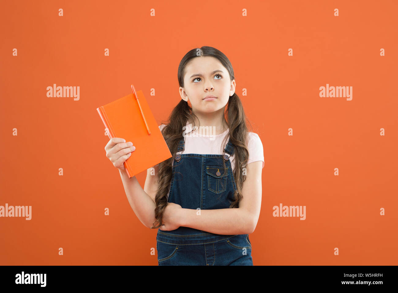 school girl read book on orange background. writing notes. kid diary. poetry  and novel. modern education. thinking little girl with notebook. literature  lesson. back to school. Diary for girl concept Stock Photo -