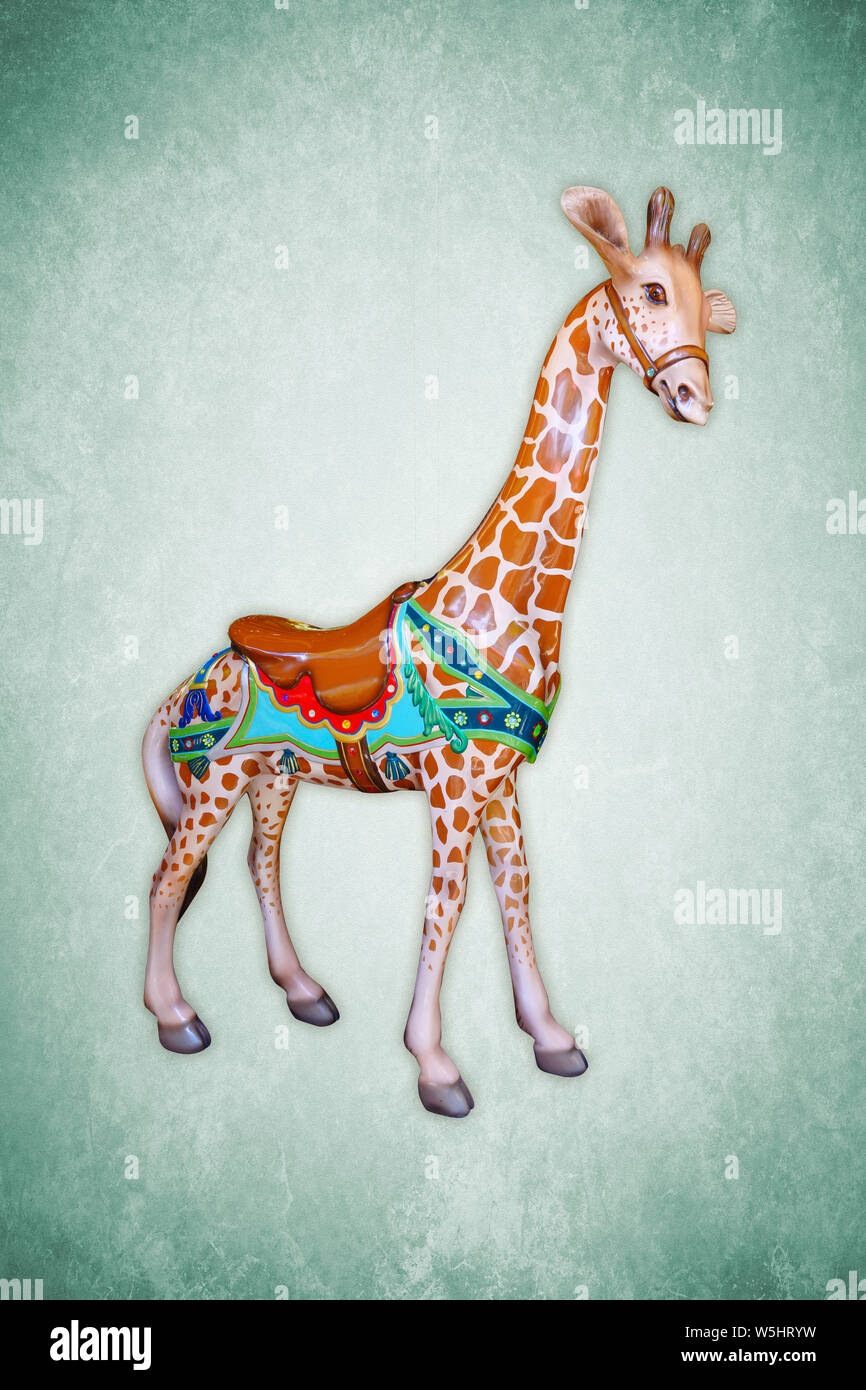 Carnival carousel giraffe isolated on green background Stock Photo