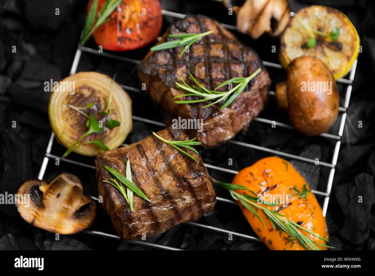 Well done meat with grilled vegetables on grate while cooking Stock