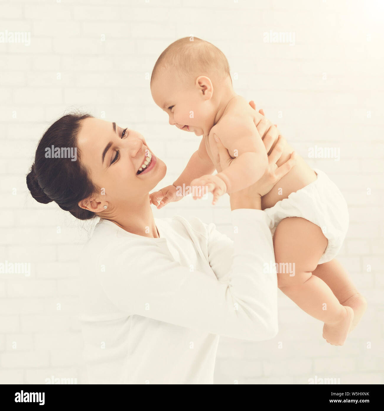 Young mom holding her happy baby in air Stock Photo - Alamy