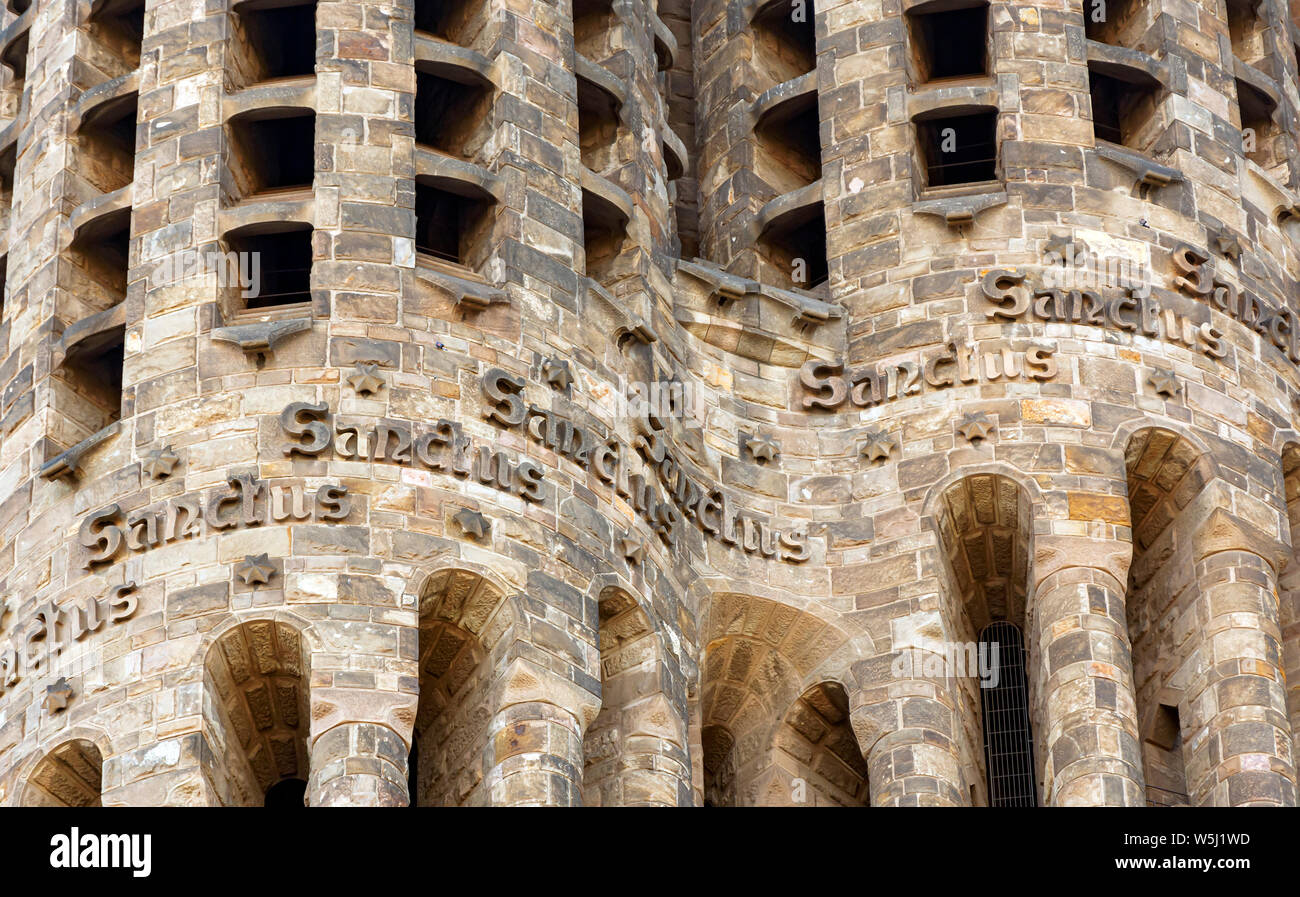 Barcelona, Spain, April 2019: Detail of the tower of the Basilica of the Sagrada Familia with the word Sanctus carved in bas-relief. The Basilica of Stock Photo