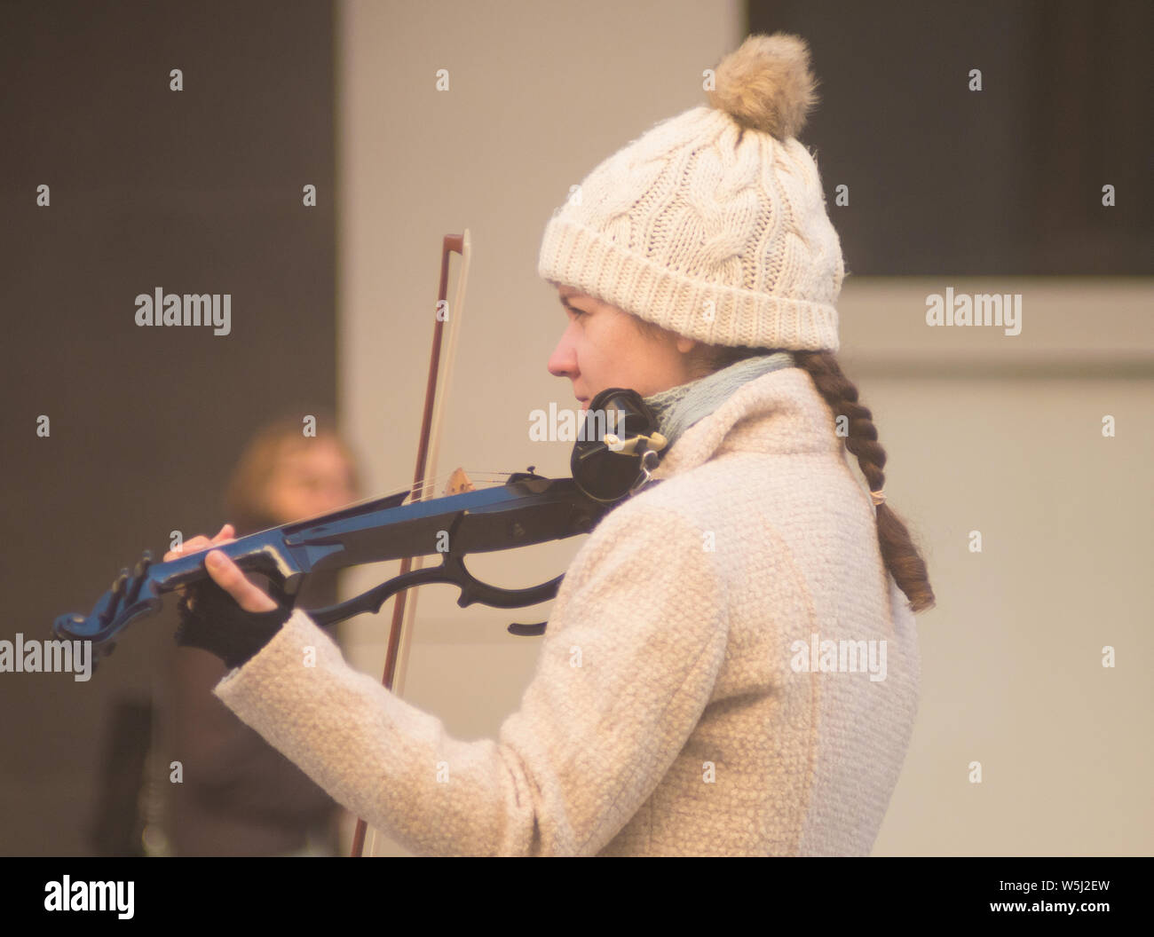 Young female violinist performs in Rundle Mall during winter in Adelaide, South Australia, Australia. Stock Photo