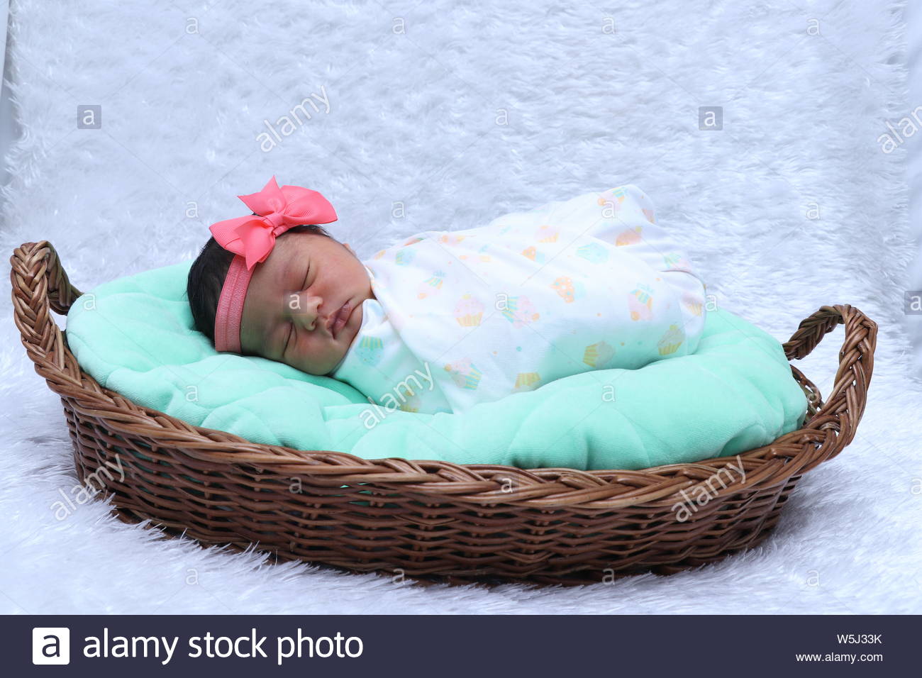 Cute New Born Baby Girl Wearing Head Band And Sleeping In Basket Stock Photo Alamy