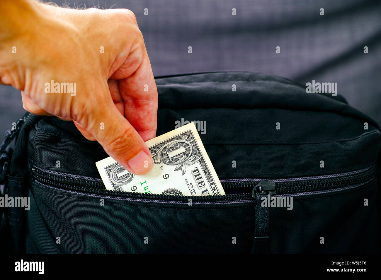 Man hand taking out money from black bag. Close up. Stock Photo