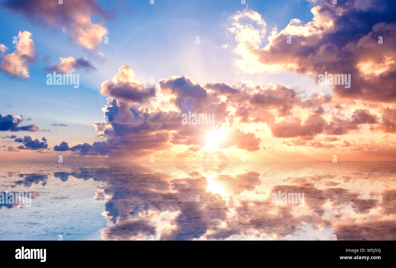 sunset sky with colorful clouds over water reflection - Stock Photo