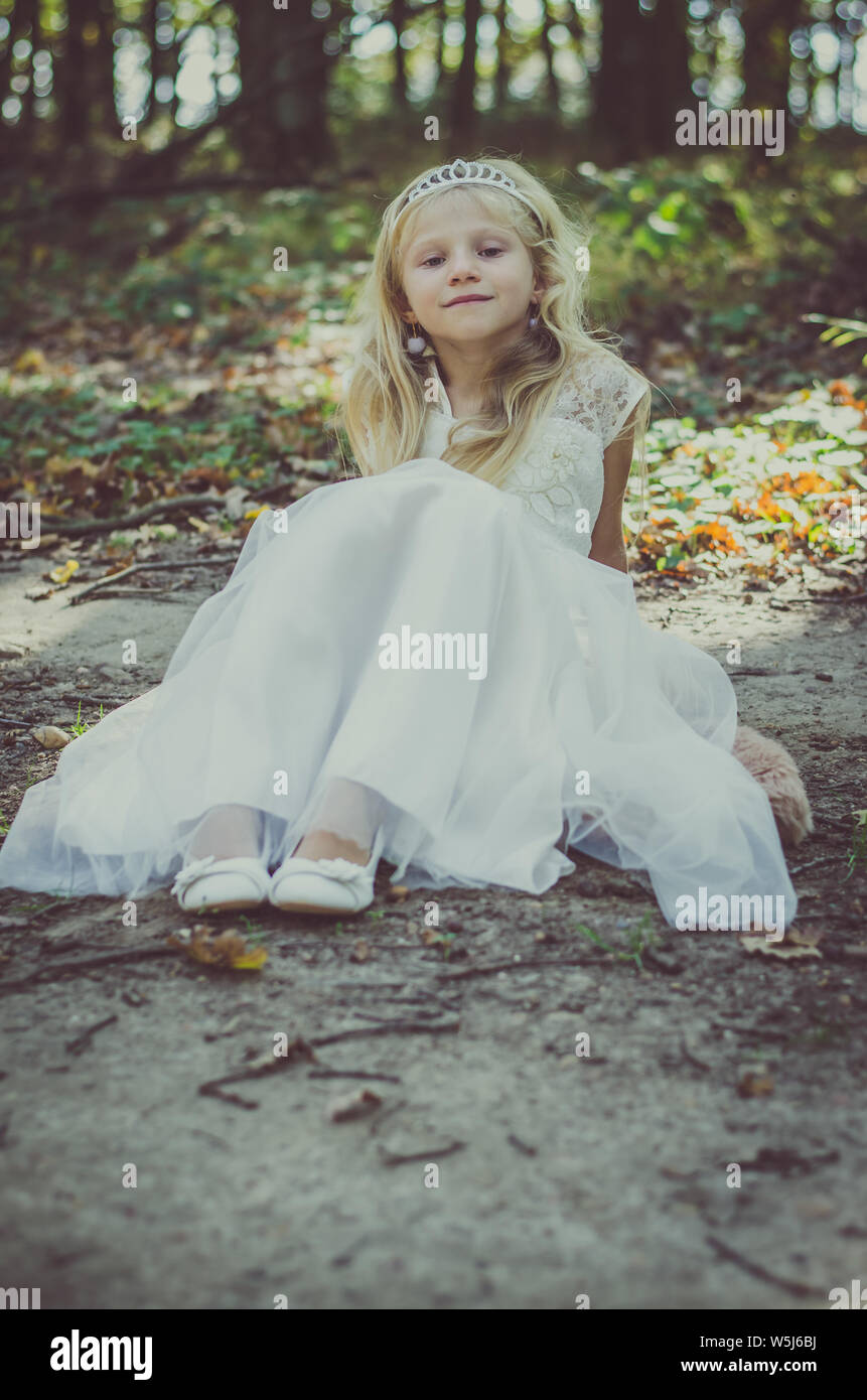 fairy princess in dress sitting in woods Stock Photo