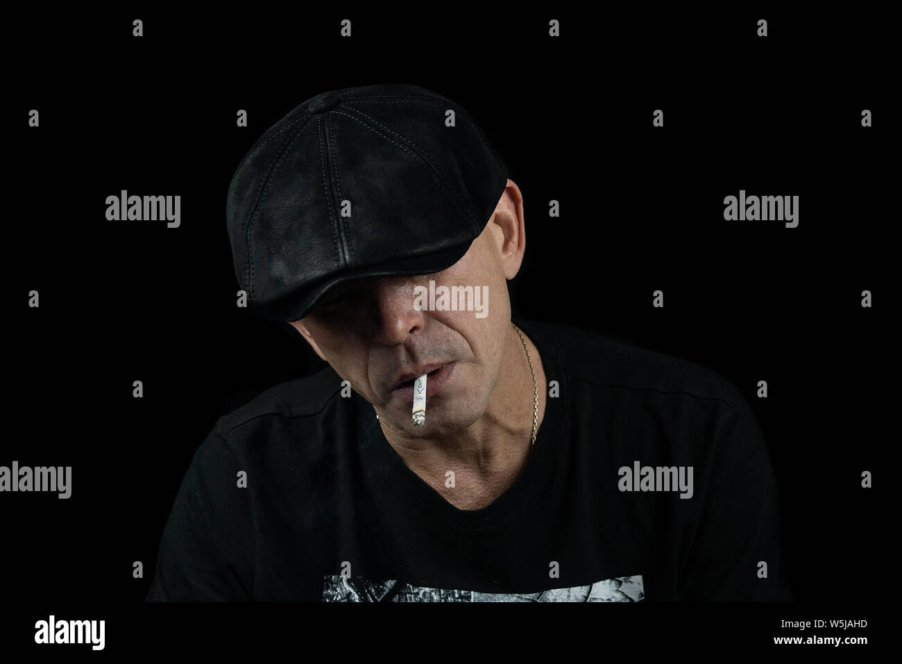 A handsome young man with a cigarette in the cloud of smoke Stock Photo