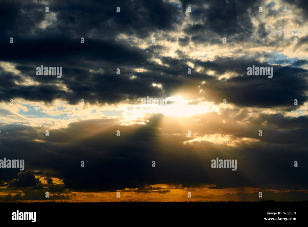 Beautiful sunset - dark sky with clouds and sunlight Stock Photo - Alamy