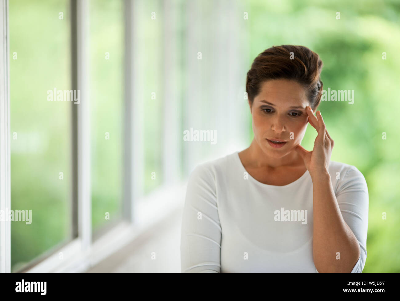 Portrait of mid adult woman looking worried. Stock Photo