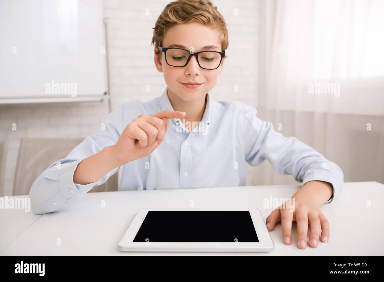 Boy with tablet pc studying in classroom Stock Photo