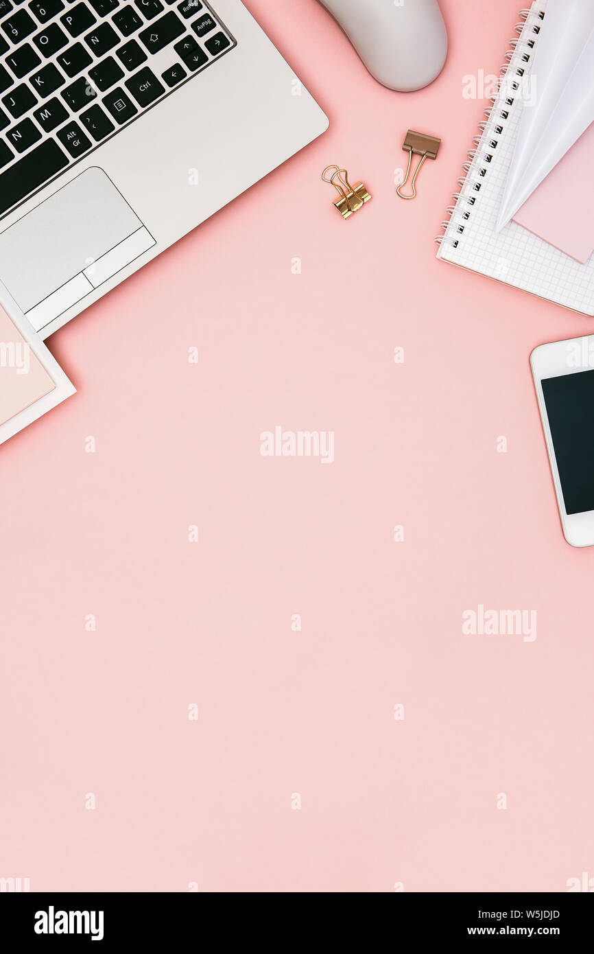 Flat lay image of pink office desk table with laptop, smartphone and copy space. Hero header concept. Top view. Stock Photo
