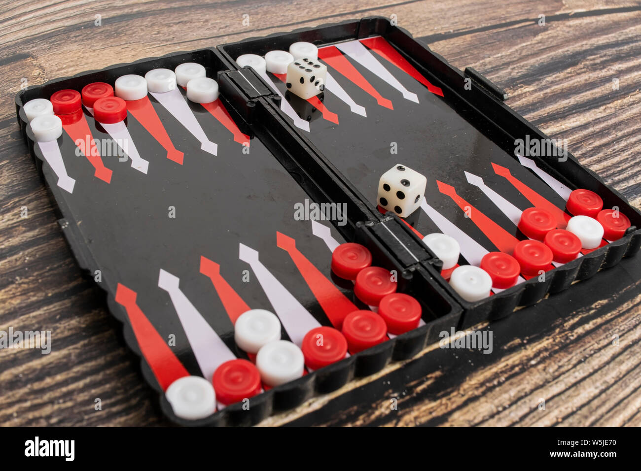 Small pocket backgammon on a wooden table. Stock Photo