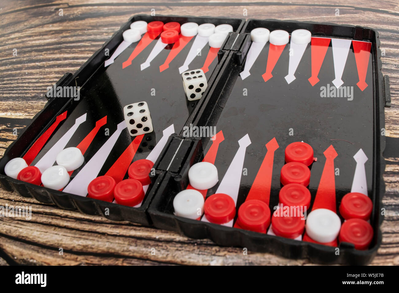 Small pocket backgammon on a wooden table. Stock Photo