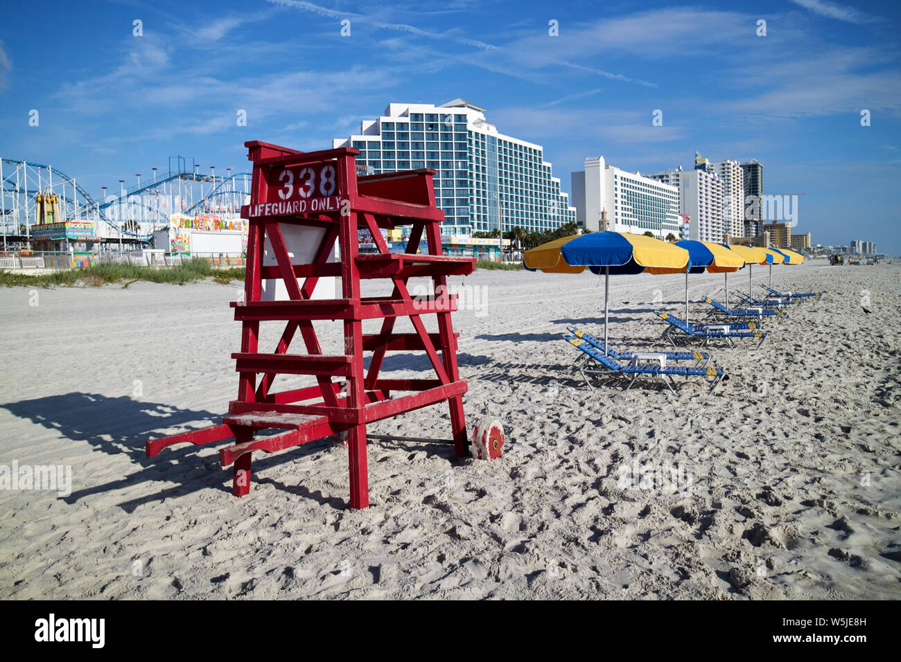 lifeguard chair and empty sun loungers and umbrellas for hire early morning daytona beach florida usa united states of america Stock Photo