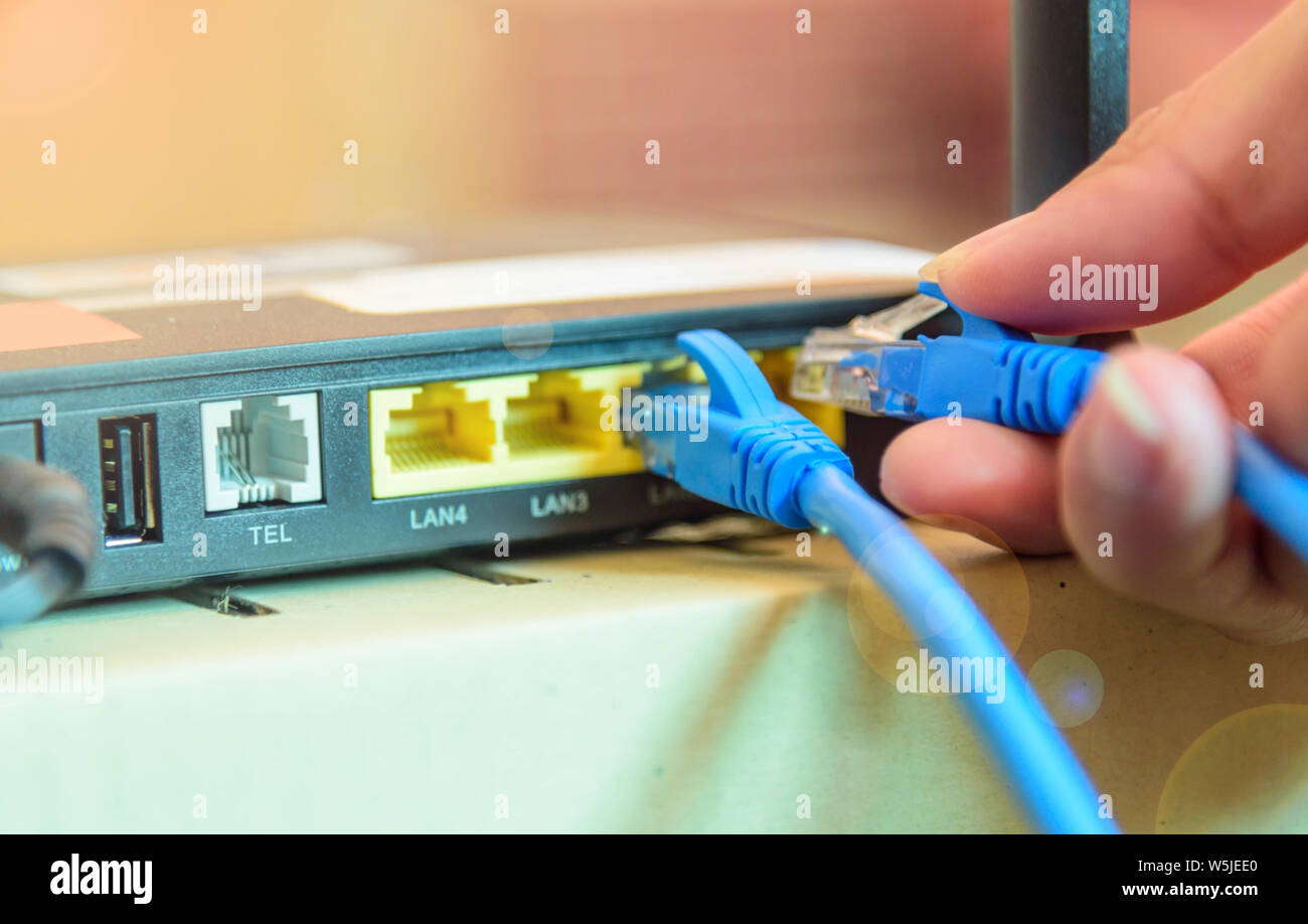 The man Connect LAN cable to router for use internet Stock Photo - Alamy
